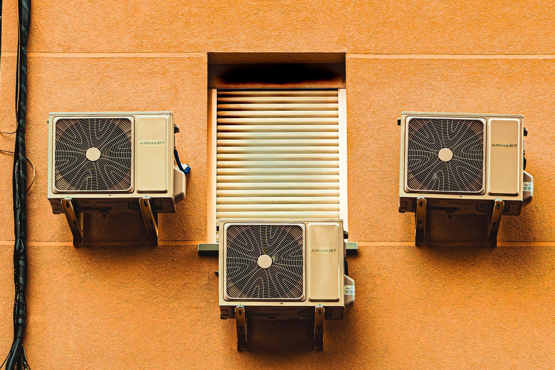 Exterior wall with three air conditioners, showcasing modern architectural elements.