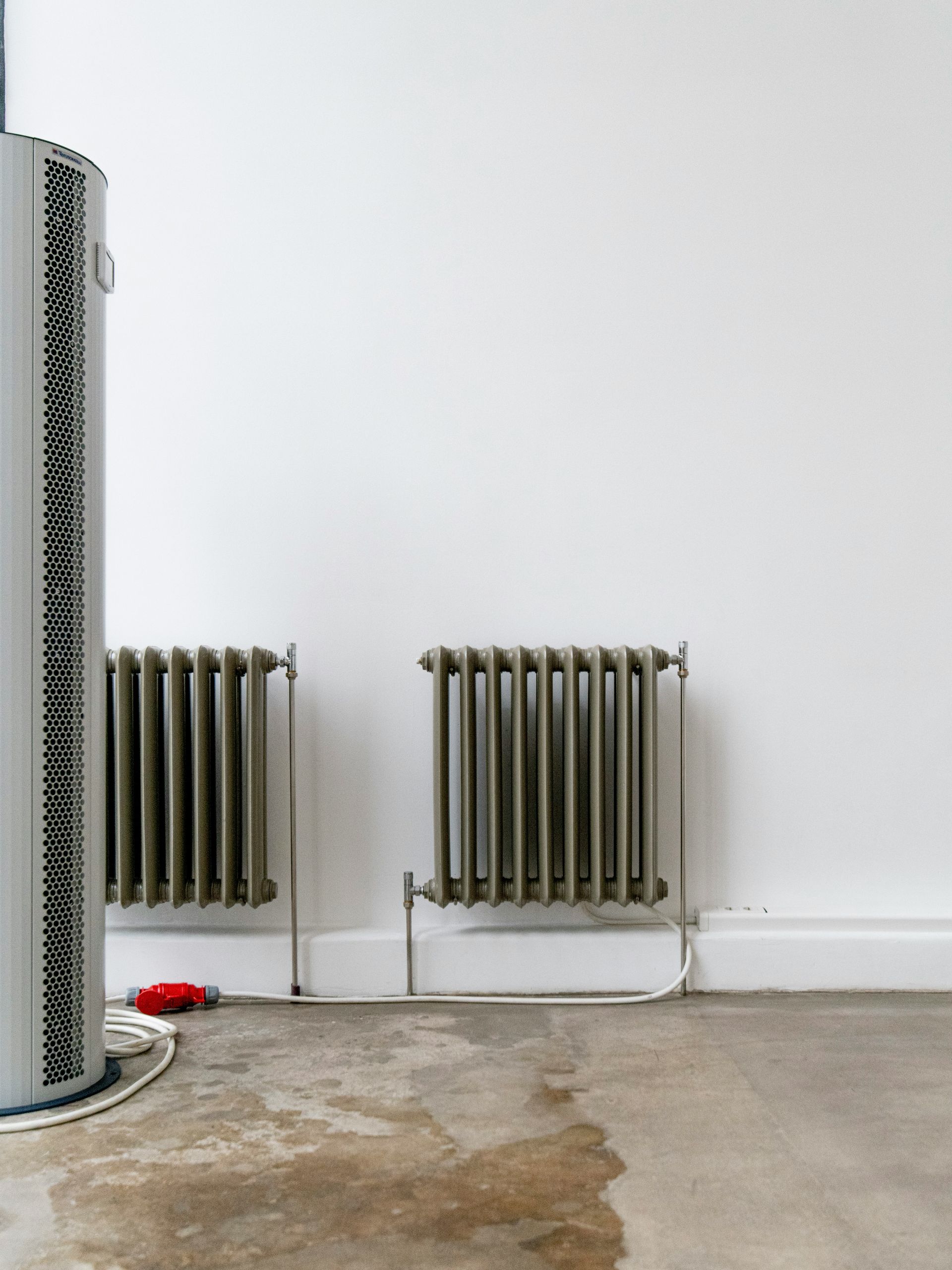 Two radiators stand against a white wall.